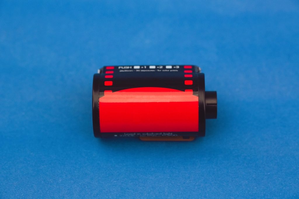 A roll of colour negative film against a plain ground